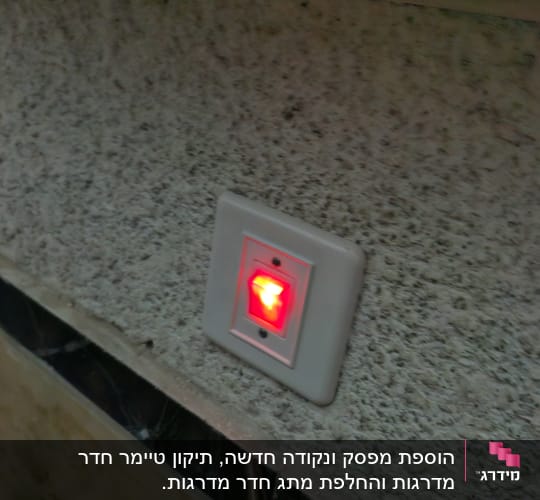 מתג חשמלי עם אור אדום דולק על קיר